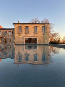 a brick building is reflected in a pool of water at Chateau de la Vieille Chapelle in Lugon et l’Ile du Carney