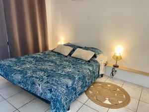 a bedroom with a bed with a blue comforter at St Martial Sète centre, CLIM in Sète
