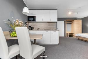 - une cuisine et une salle à manger avec des placards blancs et une table dans l'établissement Ferienwohnung Bude 4 Dagebüll, à Dagebüll