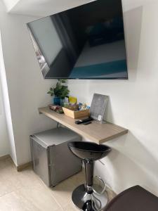 a desk with a stool and a laptop on a wall at Hotel 12 Nights in Medellín