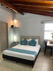 a bedroom with a bed with blue pillows and a desk at Hotel 12 Nights in Medellín