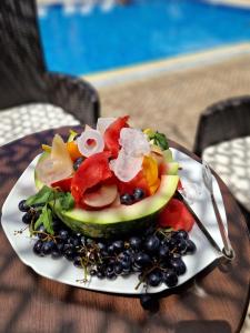 a plate of fruit and vegetables on a table at Villa Mystic in Ohrid