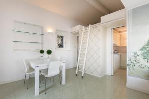 a white dining room with a white table and chairs at Maison du Lac in Stresa +9 photos