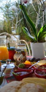 uma mesa com um prato de alimentos e uma planta em vasos em Couette Et Cafe Crème em Le Coudray