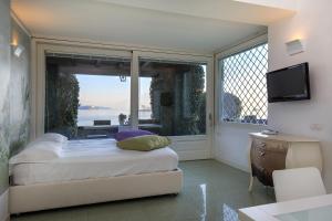 a bedroom with a bed and a large window at Maison du Lac in Stresa