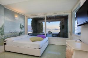 Un dormitorio con una cama y una ventana grande. en Maison du Lac, en Stresa