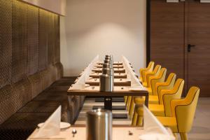 a long table in a room with yellow chairs at Budget Hotel Victoria in Budapest