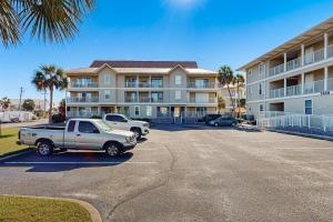 een auto geparkeerd op een parkeerplaats voor een gebouw bij Sunset Harbour Villas in Navarre