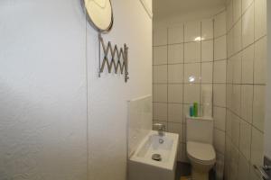 a bathroom with a toilet and a sink and a mirror at Sutton House in Sutton in Ashfield +24 photos