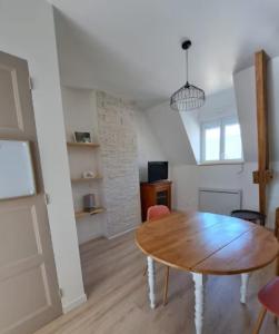 a room with a wooden table and a dining room at Appartement cosy & central in Mortain