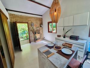 a kitchen with a table with plates on it at Casa Raiz 1 Moreré - A 3min da praia in Moreré