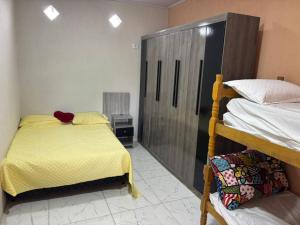 a bedroom with two bunk beds and a television at Piscina, Churrasqueira, Ar Condicionado e 3 Vagas de Garagem in Mongaguá +39 photos