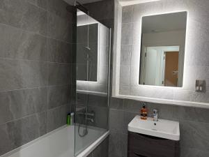 a bathroom with a shower and a sink and a mirror at Modern - City Centre - 2BR APT in Belfast