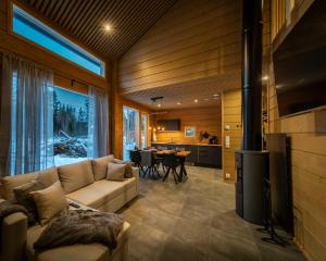a living room with a couch and a dining room at Black Work Levi Aapa in Kittilä