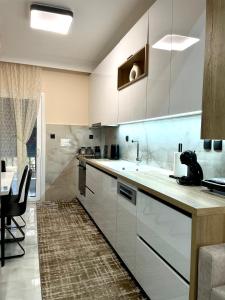 eine Küche mit weißen Schränken und einem Esstisch in der Unterkunft The MODERN apartment in Thessaloniki