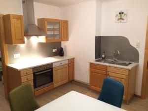 a small kitchen with wooden cabinets and a sink at Appartement Luna in Mittersill