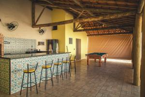 a kitchen with a bar with a table and stools at Espaço Hórus in Socorro