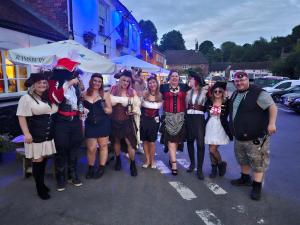 a group of people posing for a picture on a street at The Crown Aldbourne in Aldbourne
