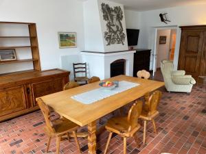 a dining room with a wooden table and chairs at Casa Andrea Chefétage by Fewotessin in Gerra