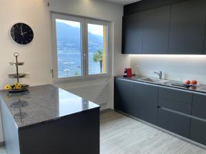 a kitchen with black cabinets and a clock on the wall at Riviera by Fewotessin in Vira