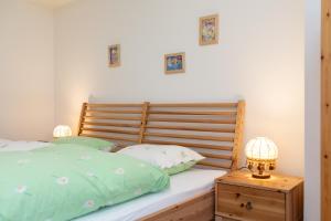 a bed with a wooden headboard and two lamps on a night stand at Apartment Puntschella Veglia in Pontresina