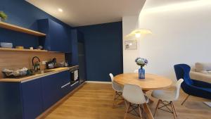 a kitchen with blue walls and a table and chairs at Apartamento Hortensia Diseño Exclusivo in Ponteareas +18 photos