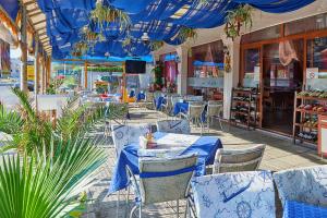 un restaurant avec des plafonds bleus, des tables et des chaises dans l'établissement Petar and Pavel Hotel & Relax Center, à Pomorie