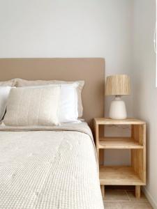 a bedroom with a bed and a nightstand with a lamp at Apartamento de un dormitorio en Edificio "Luna de Mar" in Punta del Este