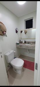 a bathroom with a white toilet and a sink at Apto vista mar in Balneário Camboriú +20 photos