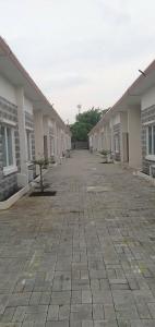 an empty courtyard of a building with a brick road at Lestari homestay in Waru Lor