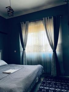 a bedroom with a bed and a window at Jolta Inn in Kampala