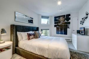 a bedroom with a large white bed and a window at Ski-In-Out, Pool, Hot Tub, Sauna in Whistler +17 photos