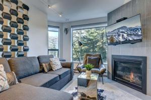 a living room with a couch and a fireplace at Ski-In-Out, Pool, Hot Tub, Sauna in Whistler