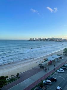 a view of a beach with a building and the ocean at Apartamento grande FRENTE MAR in Guarapari