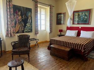 a bedroom with a bed and a chair and a painting at Principauté in Gorée +74 photos