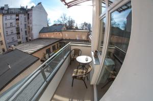 einen Balkon mit einem Tisch und Stühlen auf einem Gebäude in der Unterkunft Apartman Relax Olomouc in Olomouc