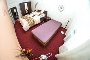 オロモウツにあるApartman Relax Olomoucのベッドルーム(紫色のオットマン付きベッド1台付)