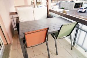 NeirivueにあるGruyère Alpes Appartement 3 chambres BBQ Parkingの木製テーブル、椅子2脚