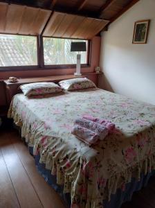 a bedroom with a bed in a room with windows at Suite Beija-flor Caborê Paraty in Paraty