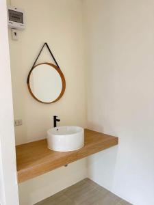 a bathroom with a white sink and a mirror at ร เรือ รีสอร์ท in Ban Khao Noi
