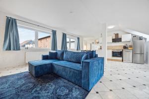 ein blaues Sofa im Wohnzimmer mit Küche in der Unterkunft Amigo 2 in Schwerin