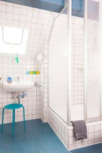 a white bathroom with a sink and a shower at Drifthuus 2 groß in Spiekeroog