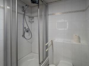a white bathroom with a shower and a toilet at Huus Jan in Spiekeroog +25 photos