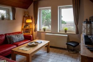 a living room with a couch and a table and two windows at Huus Jan in Spiekeroog