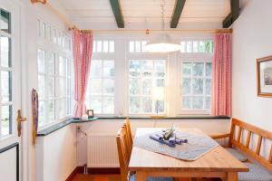 a dining room with a table and some windows at Drifthuus 1 klein in Spiekeroog