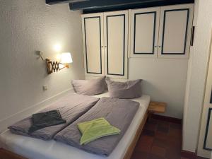 a bed with two pillows on it in a bedroom at Drifthuus 1 klein in Spiekeroog