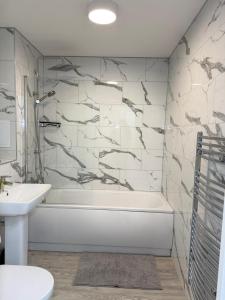 a bathroom with a white tub and a sink at Serenity Waterfront 2 Bed Apartment in Northfleet +104 photos