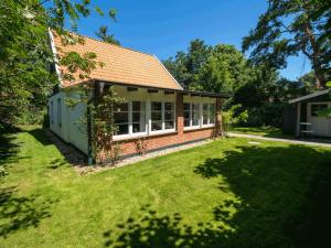 a small brick house with a grass yard at Pastors Tuun in Spiekeroog