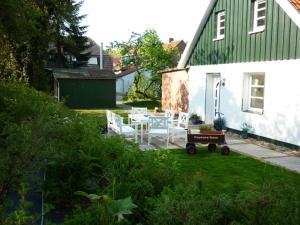 a white house with a table and chairs in the yard at Pastors Tuun in Spiekeroog +25 photos