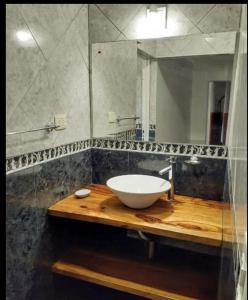 une salle de bain avec un lavabo et un miroir dans l'établissement Departamentos Mama carmen, à Mina Clavero